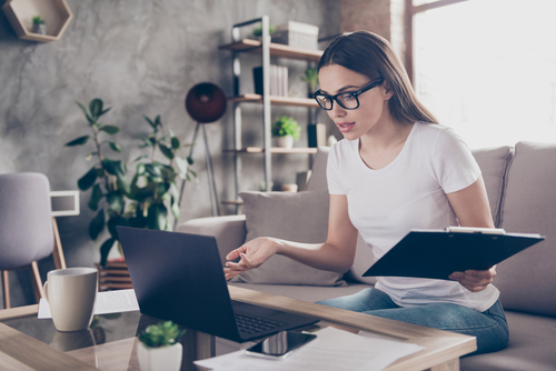 Business woman on computer with clipboard