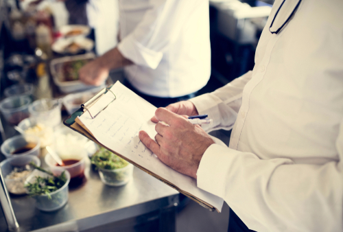 Closeup of chef hand checking menu list