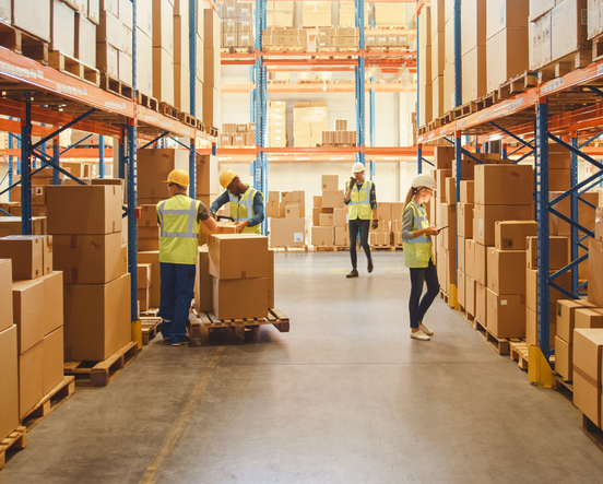 Retail Warehouse full of Shelves with Goods in Cardboard Boxes, Workers Scan and Sort Packages, Move Inventory with Pallet Trucks and Forklifts. Product Distribution Delivery Center.