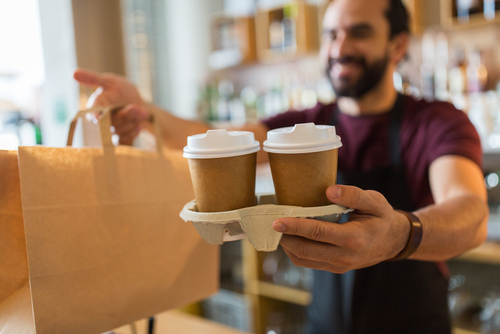 small business, people and service concept - man or bartender serving customer at coffee shop